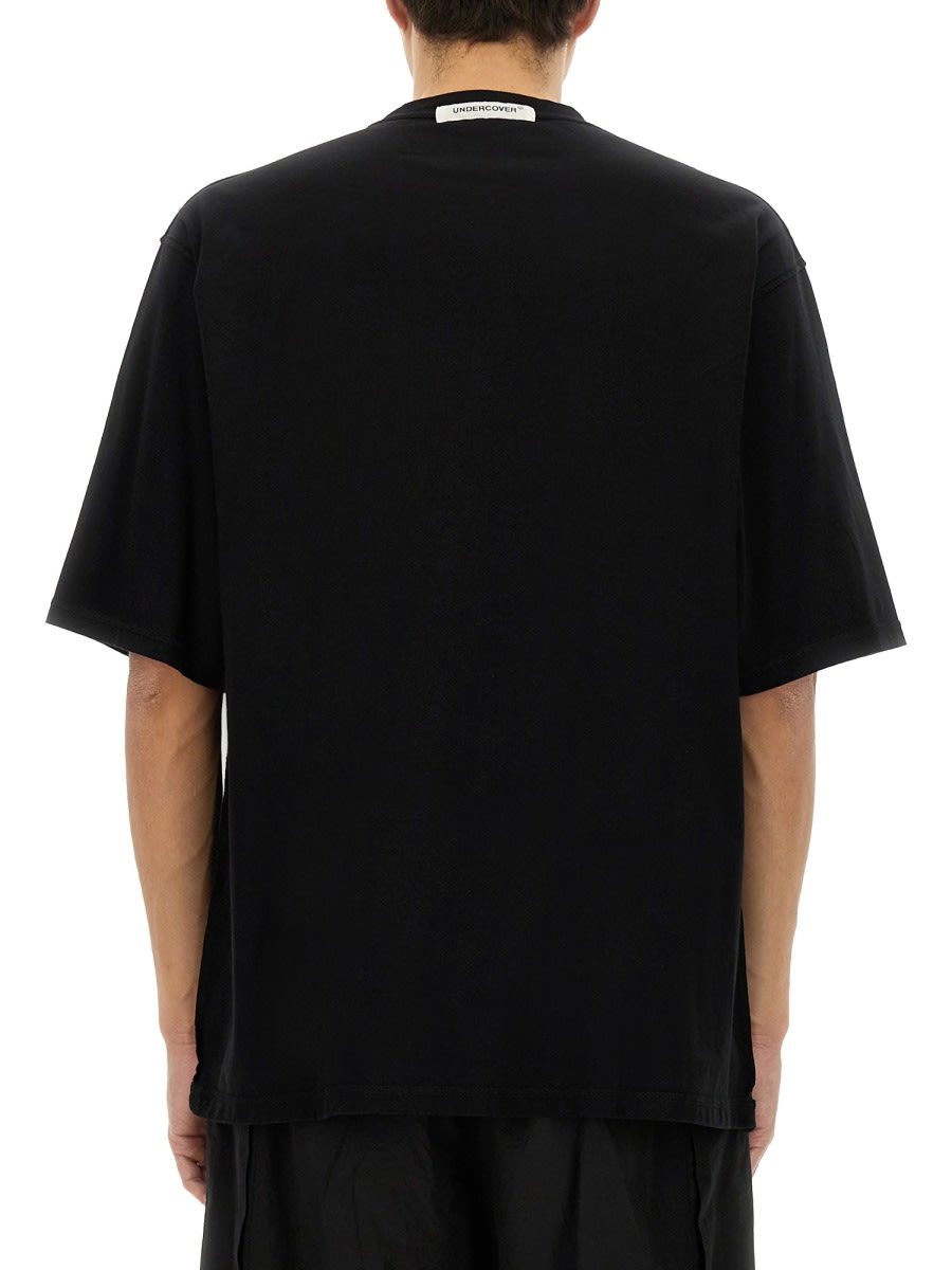 Undercover Graphic Print Black T-shirt With Exposed-seam Detailing And Logo Patch In Black